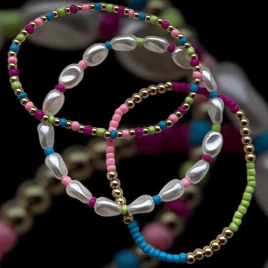 “Set of 3 pastel beaded bracelets with faux pearls on soft white background”