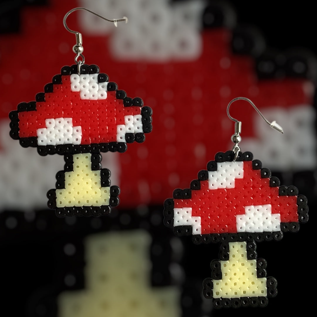 Handmade fuse bead earrings featuring red pixel-style toadstool design with nickel-free hook findings on kraft card backing