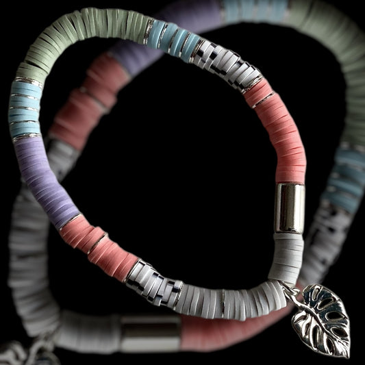 Soft pastel bracelet with silver leaf charm

Handmade stretch bracelet in muted tones

Spring-inspired bracelet with botanical charm